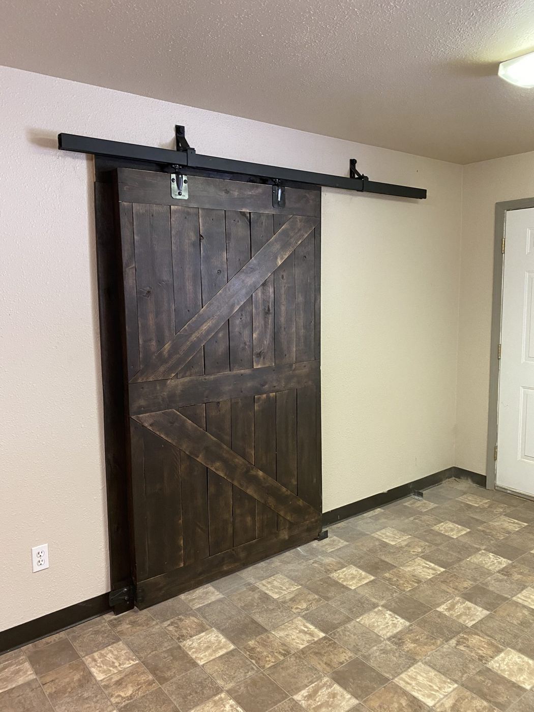 Stained sliding barn door hung on black hardware