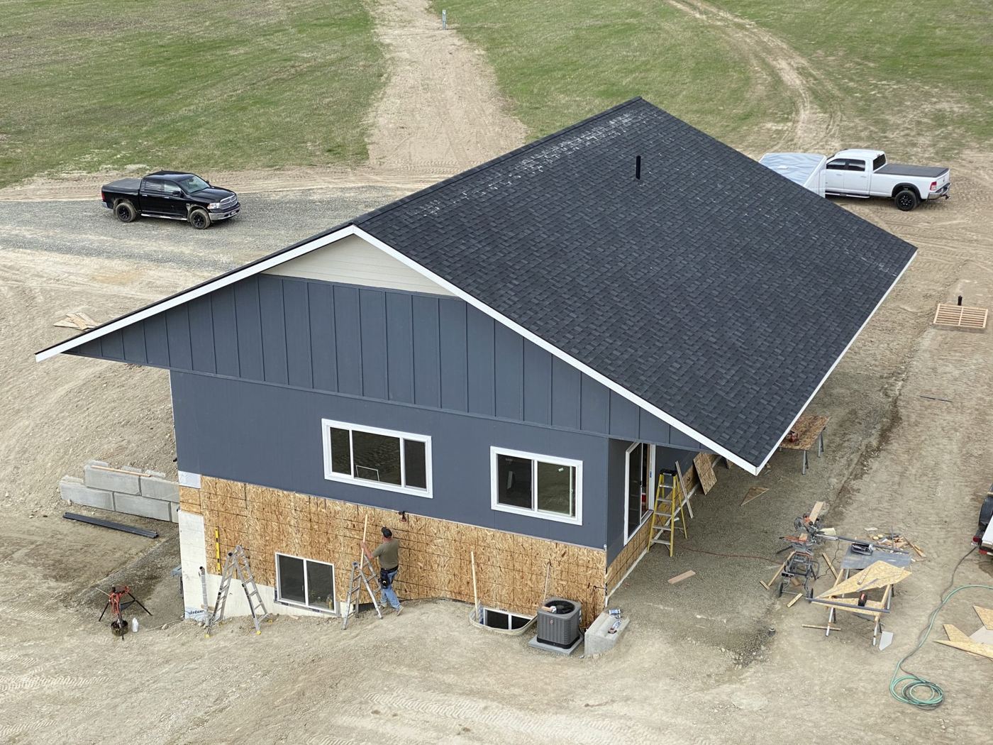 Finished house with dark siding and a metal roof