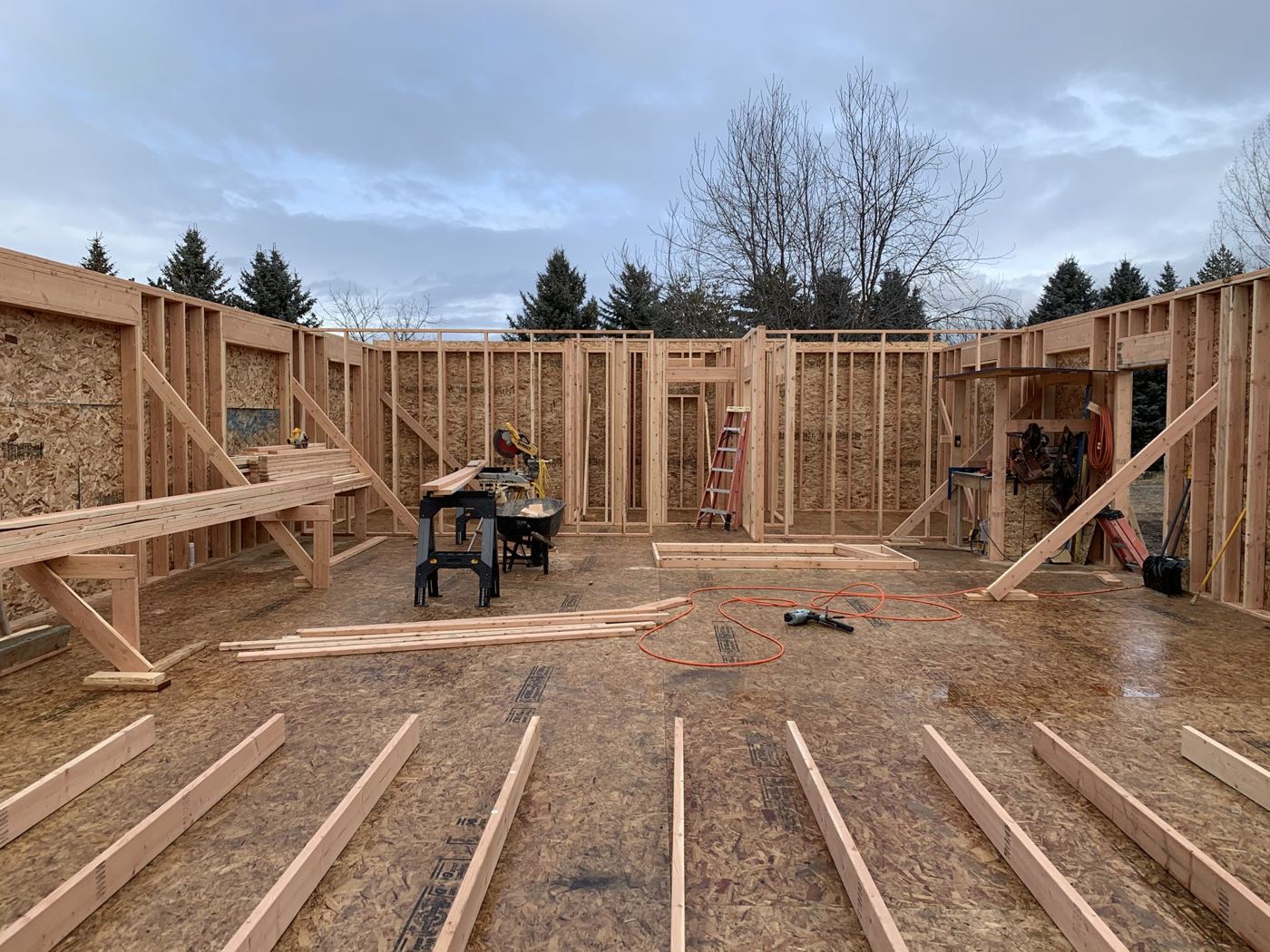 Framing standing in the snow on a winter job site