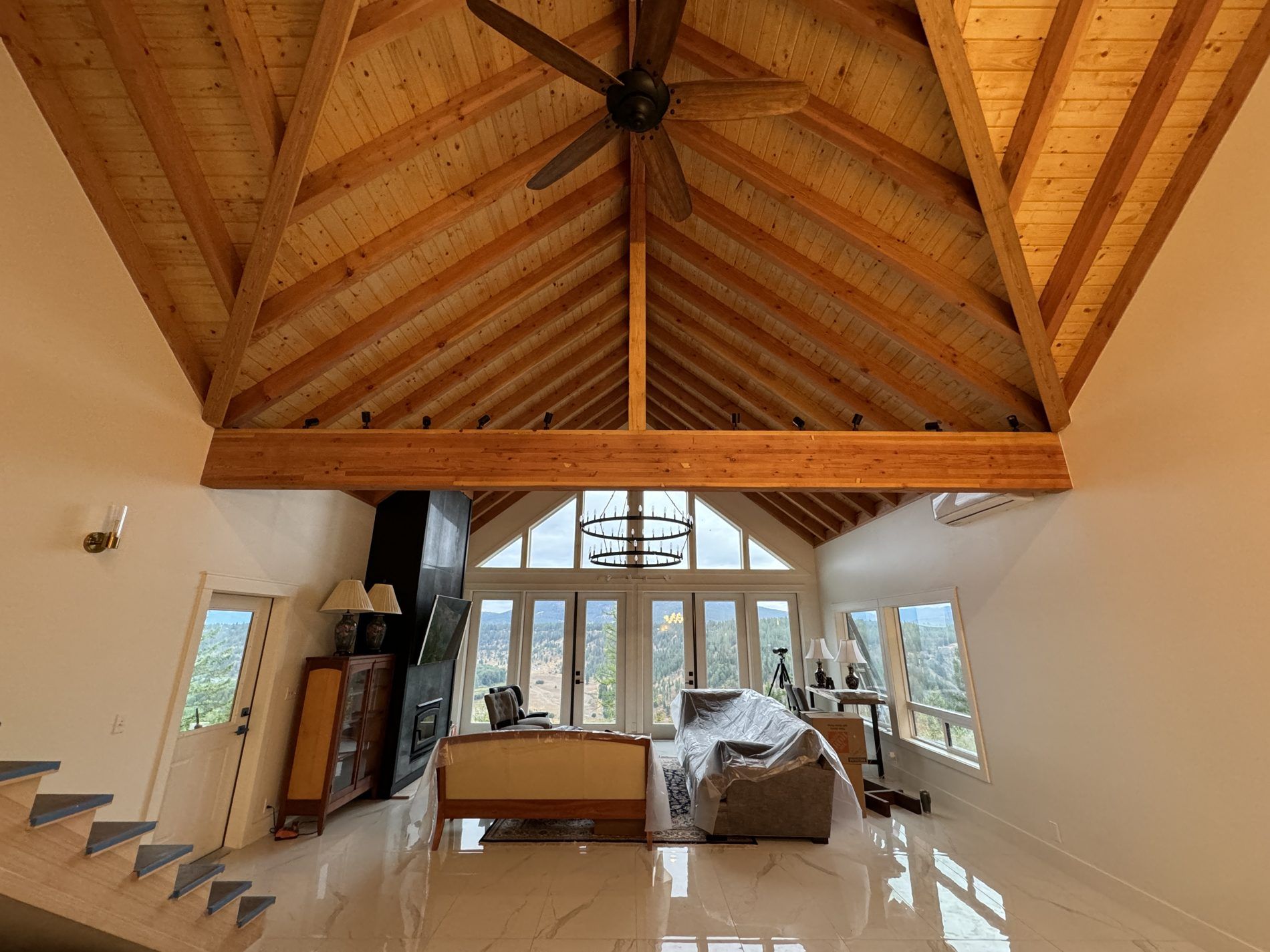 Great room with exposed timber trusses and a tongue-and-groove ceiling