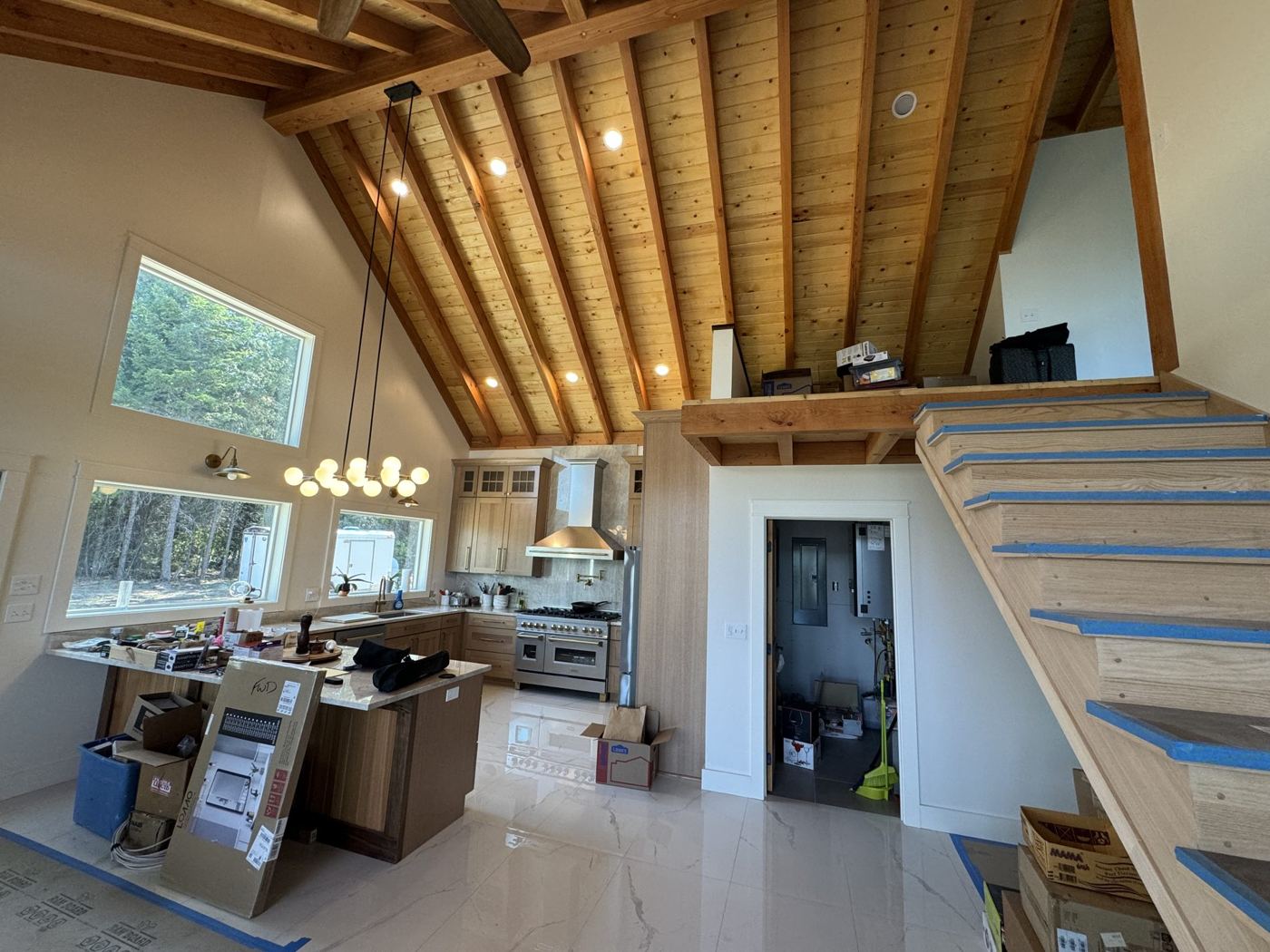 Kitchen and open stair below a wood-beamed ceiling