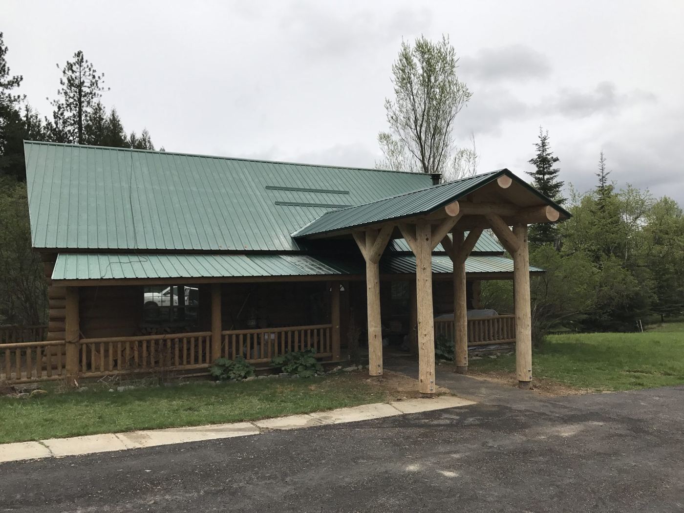 Finished log lodge with a green standing-seam roof and timber entry