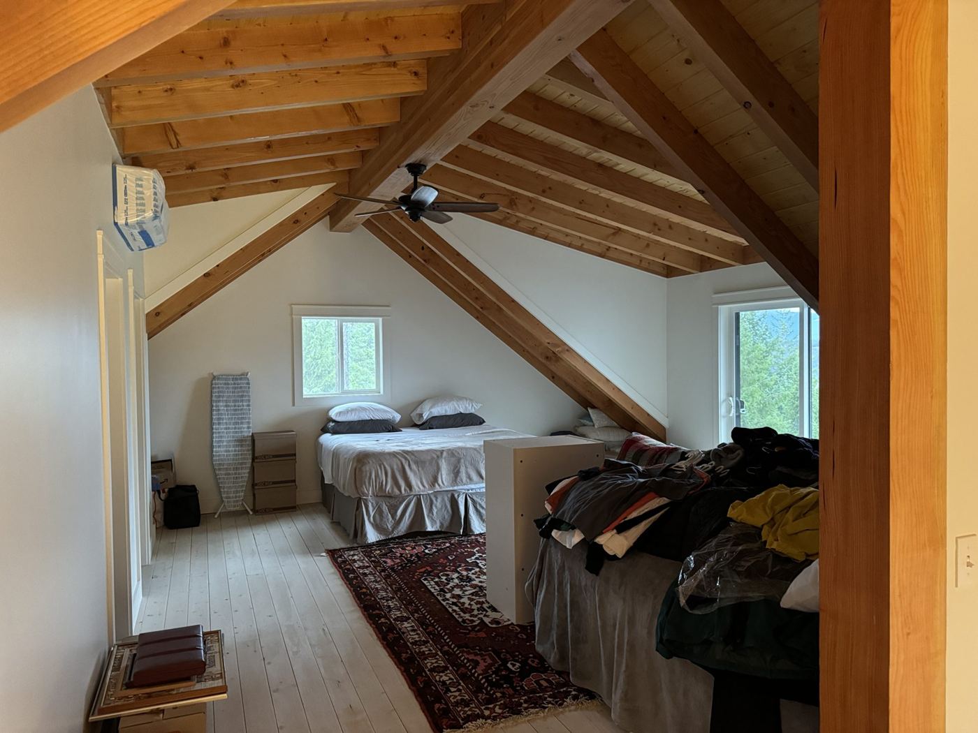 Upstairs loft framed by exposed timber and wood ceiling