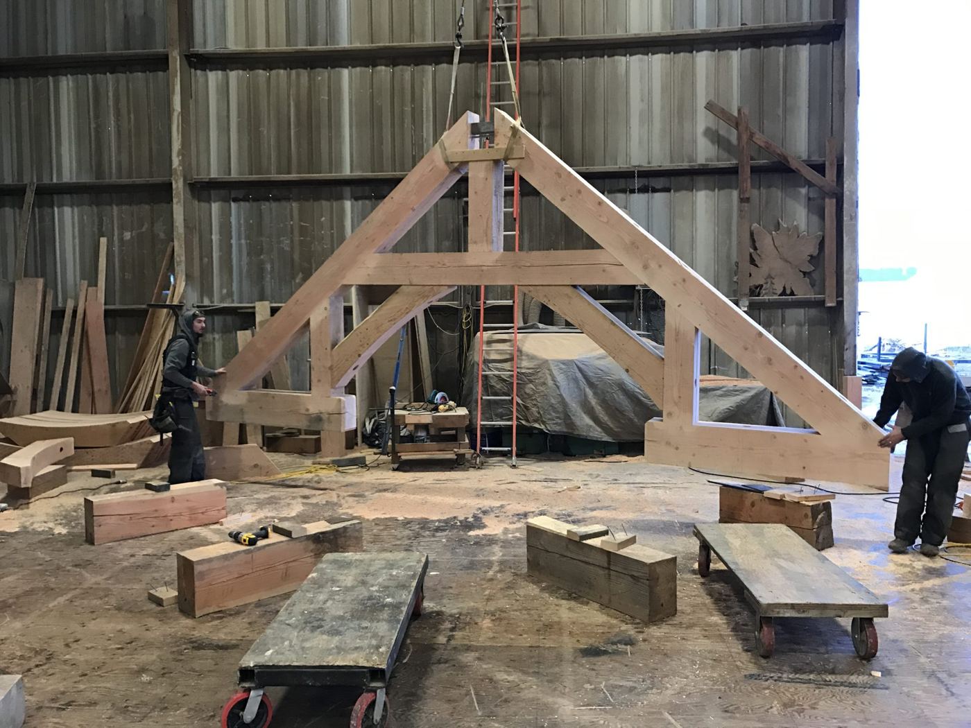 A timber truss assembled and standing inside the shop